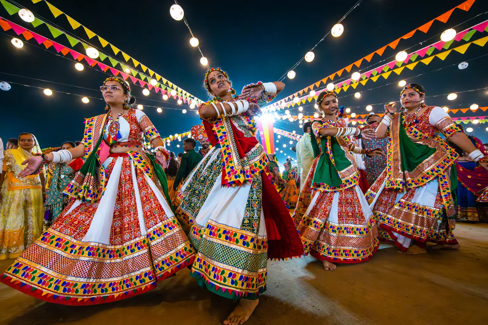 Garba dancers under string lights on a Navratri night